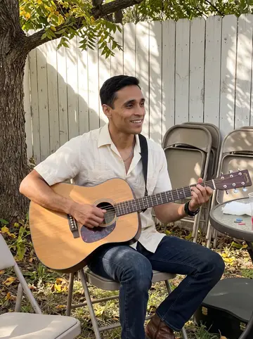 Joaquín, AI character: his abuelo's backyard in San Antonio, under a pecan tree with folding chairs and a small patio table