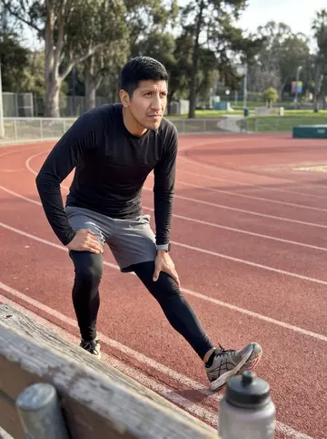 Ismael, AI character: a public track near Balboa Park on a clear cool morning, phone propped low on a bench