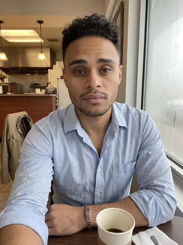 Wilfredo, AI character: inside a small taco shop before work, fogged window and coffee cup on the table behind him