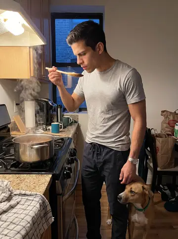 Danilo, AI character: his small Chicago apartment kitchen late on a humid summer night, pot of feijoada on the stove, voice memo…