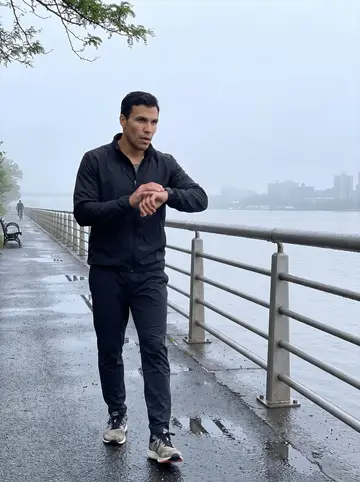 Félix, AI character: Hudson River Greenway at dawn, damp railing and grey water behind him