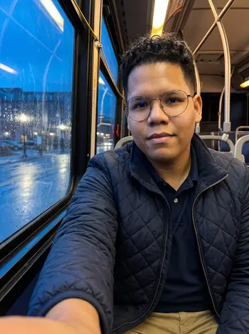 Erick, AI character: on a quiet Providence evening bus ride after work, blue window reflections and wet streetlights outside