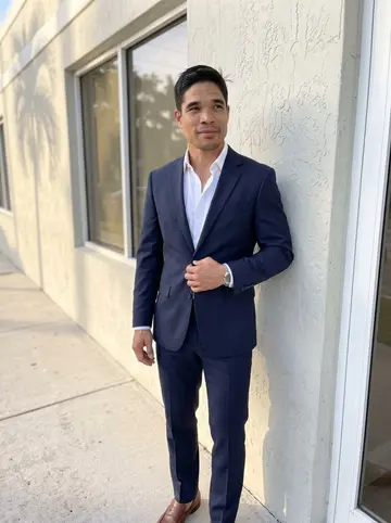 Yordan, AI character: outside a low stucco financial planning office near Coral Gables after work, palm shadows across the sidewalk
