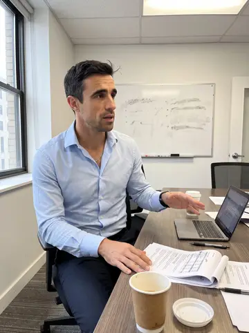 Ruaridh, AI character: a quiet hospital finance conference room in Houston, laptop open beside paper coffee cups and a stack of…