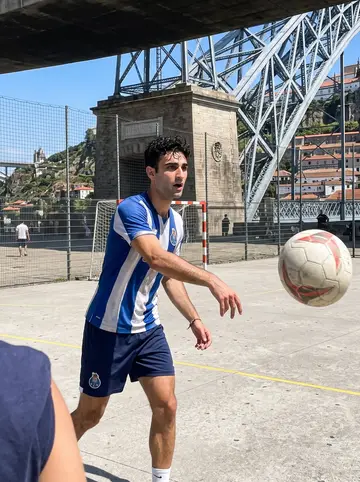 Vasco, AI character: a concrete football court under the Dom Luís bridge with cousins just outside the crop