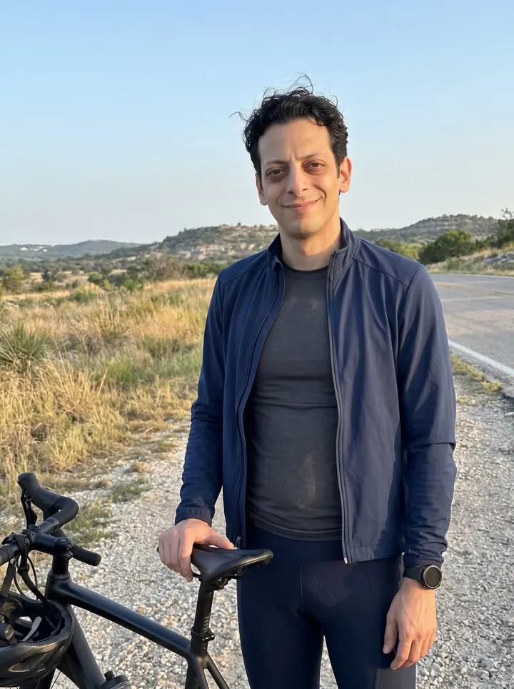 Jaime, AI character: a quiet Hill Country overlook outside Austin just after a dawn cycling route, dry grass and low limestone…