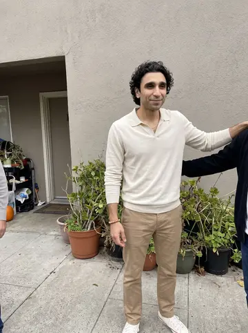 Denis, AI character: outside his sister's apartment building after a wedding-planning lunch, relatives mostly cropped out…