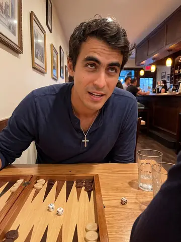 Napoleon, AI character: a corner taverna in Astoria at night, backgammon board open on a small wooden table, uncle's sleeve…