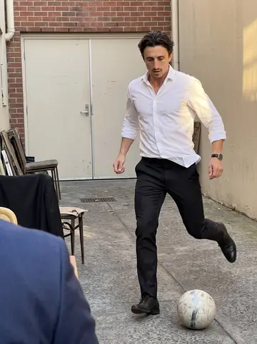 Federico, AI character: a quiet side street behind the restaurant after Sunday lunch service, staff playing football between…