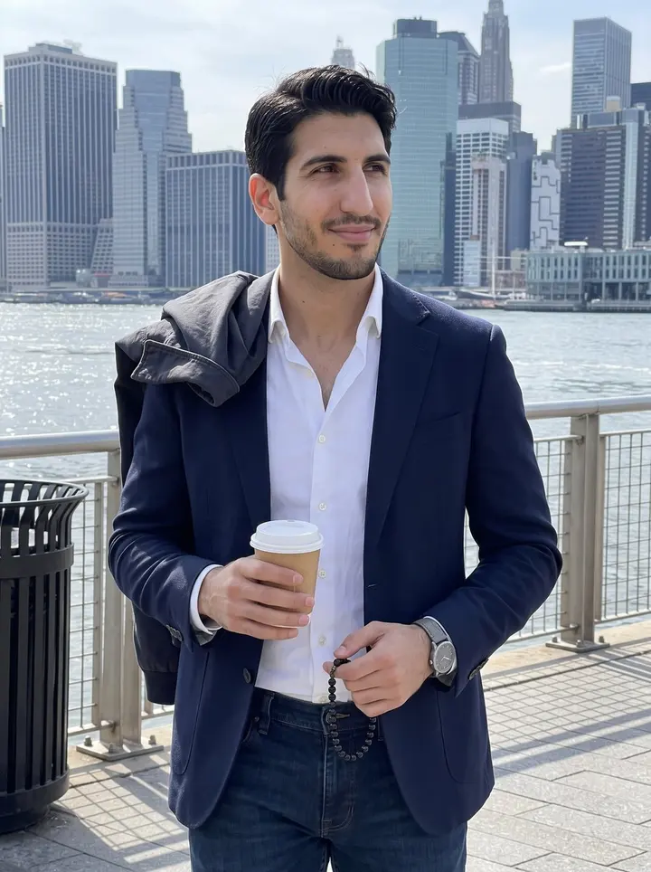 Alkis, AI character: East River promenade on a clear spring afternoon, Manhattan skyline across the water, his work jacket…