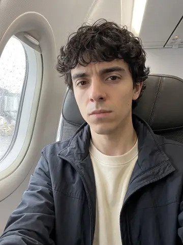 Álvaro, AI character: window seat on a short flight back through Tampa, grey rain streaking the airplane window