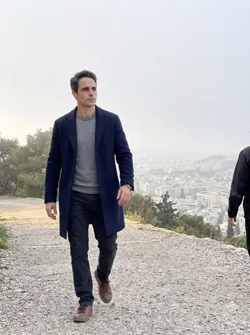 Ioannis, AI character: the path up Lycabettus hill just after sunrise, Athens still hazy below the trees