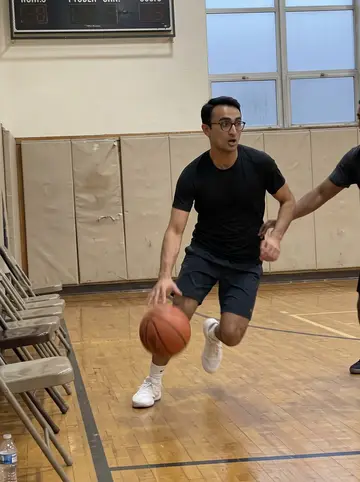 Aaron, AI character: Tuesday night pickup basketball at a church gym in Bridgeport, old wood floor, folding chairs and a…