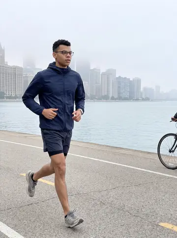 Owain, AI character: the Lakefront Trail in Chicago at dawn with the lake and a hazy skyline behind him