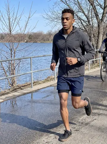 Jelani, AI character: the path around Lake Harriet in Minneapolis during a weekend training run, lake water and bare spring…