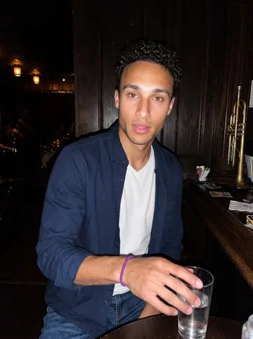 Ryan, AI character: a small Cleveland jazz bar after a late shift, brass instruments and dark wood behind him