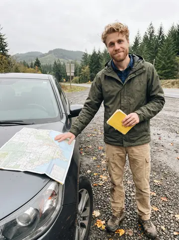Spencer, AI character: a wood-paneled corner booth in a Portland neighborhood brewpub, rain on the window behind him