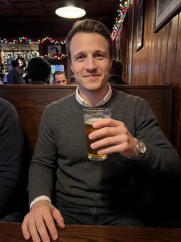 George, AI character: a low-key neighborhood bar in Chicago after a tenant meeting, holiday string lights over dark wood booths