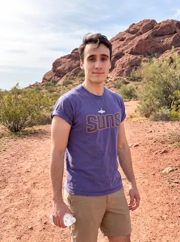 Miguel, AI character: Papago Park in Phoenix just after an early desert walk, red rock and pale spring sky behind him