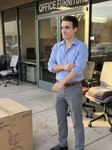 Miguel, AI character: outside an office furniture showroom in Tempe during a late afternoon work break