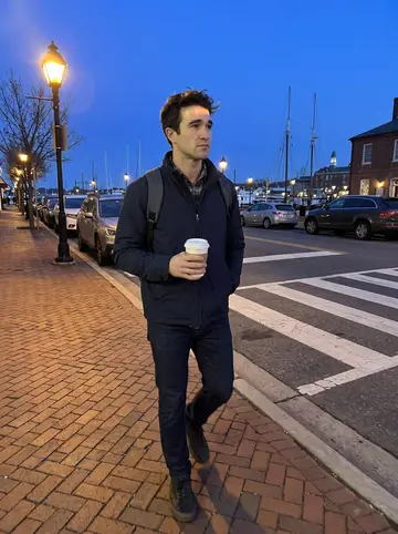 Cade, AI character: a cold Annapolis street near the harbor after work, brick sidewalk, parked cars, and blue evening sky
