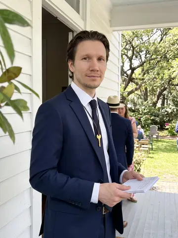 Donovan, AI character: a small Savannah garden wedding just after the ceremony, standing in the open doorway of an old white…