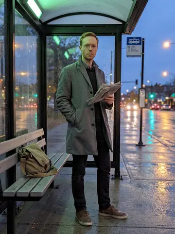 Scott, AI character: a covered bus stop near Lake Street in Minneapolis during light drizzle, wet pavement reflecting traffic…