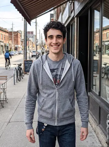 Ali, AI character: Queen Street West in Toronto on a bright spring afternoon, outside a row of small cafés and record shops