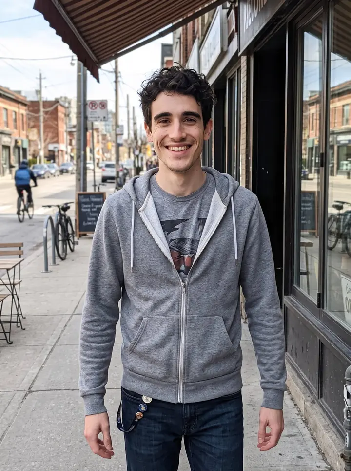 Ali, AI character: Queen Street West in Toronto on a bright spring afternoon, outside a row of small cafés and record shops