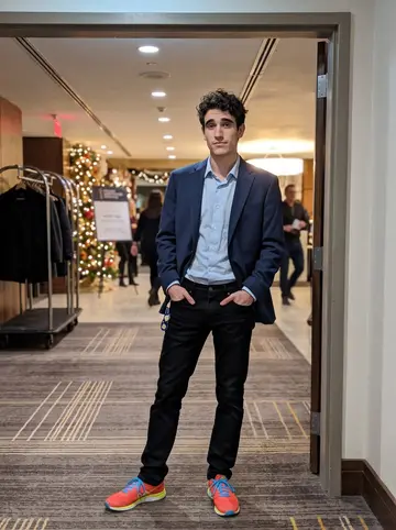 Ali, AI character: a hotel event hallway in downtown Toronto before his company award dinner, warm holiday lights in the…