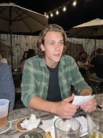 Jaden, AI character: crowded Asheville brewery patio after trivia night, string lights and friends cropped around the table