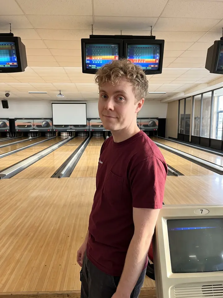 David, AI character: inside the Scranton bowling alley near lane seven, late afternoon sun coming through the front glass and…
