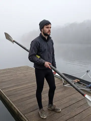 Orlando, AI character: a quiet reservoir pontoon outside Brighton at dawn, single scull pulled up beside the water