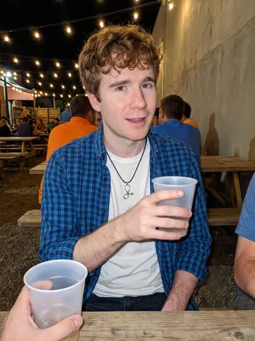 Griffin, AI character: a casual Boise brewery patio after a Boise State game, string lights, crowded picnic tables,…