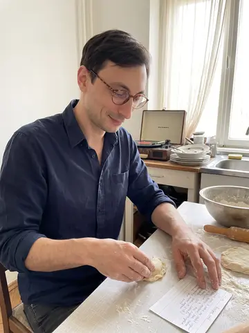 Dmytro, AI character: his small apartment kitchen, flour-dusted table, a mixing bowl, and an old record player on the counter
