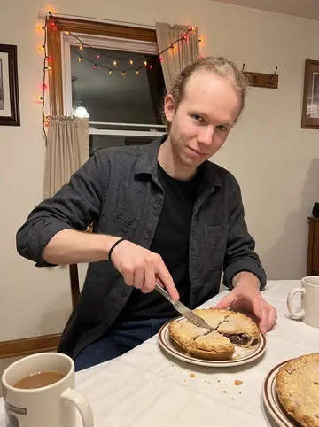 Johannes, AI character: his grandmother's kitchen table in Lancaster County during a winter family visit, shoofly pie, mugs, and…