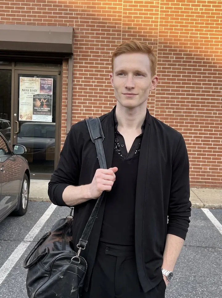 Lukáš, AI character: outside a small Allentown ballroom competition venue just before his heat, brick wall and parked cars…
