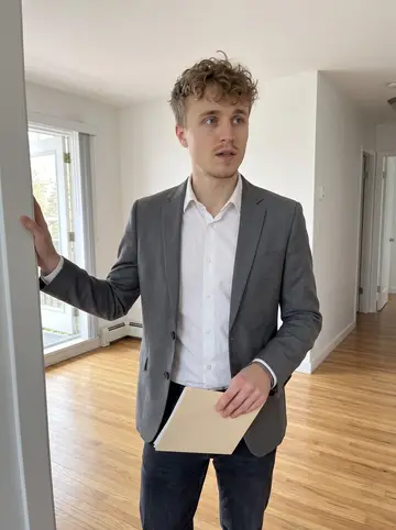 Ilari, AI character: a bright empty rental apartment in Kitsilano during a showing, white walls, hardwood floor, balcony door open