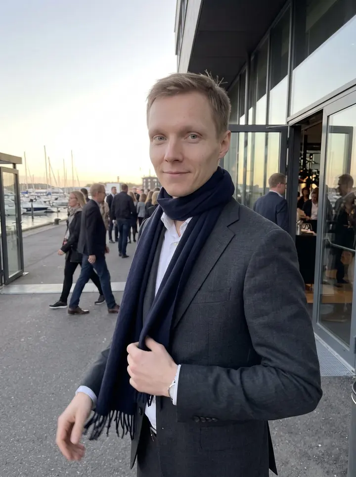 Mikael, AI character: outside a waterfront company dinner venue near the harbor, glass doors and moored boats behind him