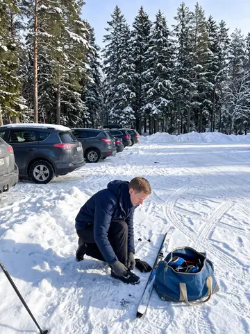 Mikael, AI character: a cross-country ski trail parking area outside the city, snowbanks and pine trees behind him