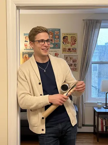 Heikki, AI character: his living room doorway, a cluster of ridiculous 1950s dental posters pinned on the wall behind him while…