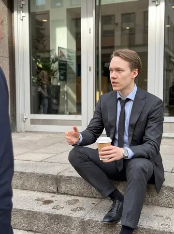 Hampus, AI character: on the stone steps outside his office building near Avenyn during a short lunch break