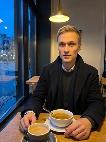 Sami, AI character: a small late-evening soup cafe near Rotuaari after rain, window glass dark behind him and wet pavement outside