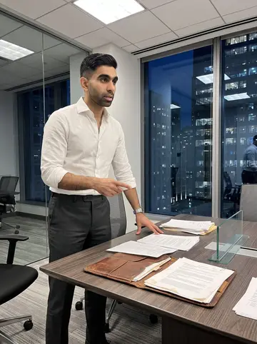Fadi, AI character: a high-floor Loop conference room after business hours, city lights through the windows, papers spread…