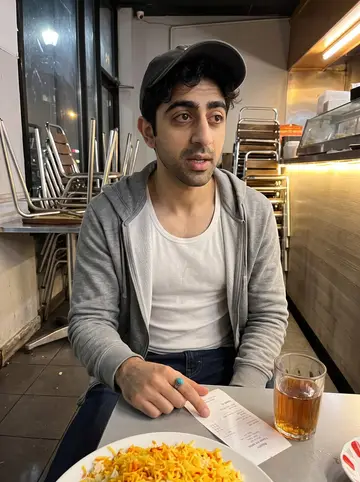Behnam, AI character: his cousin's small kebab restaurant in Los Angeles after closing, metal tables stacked to one side and the…