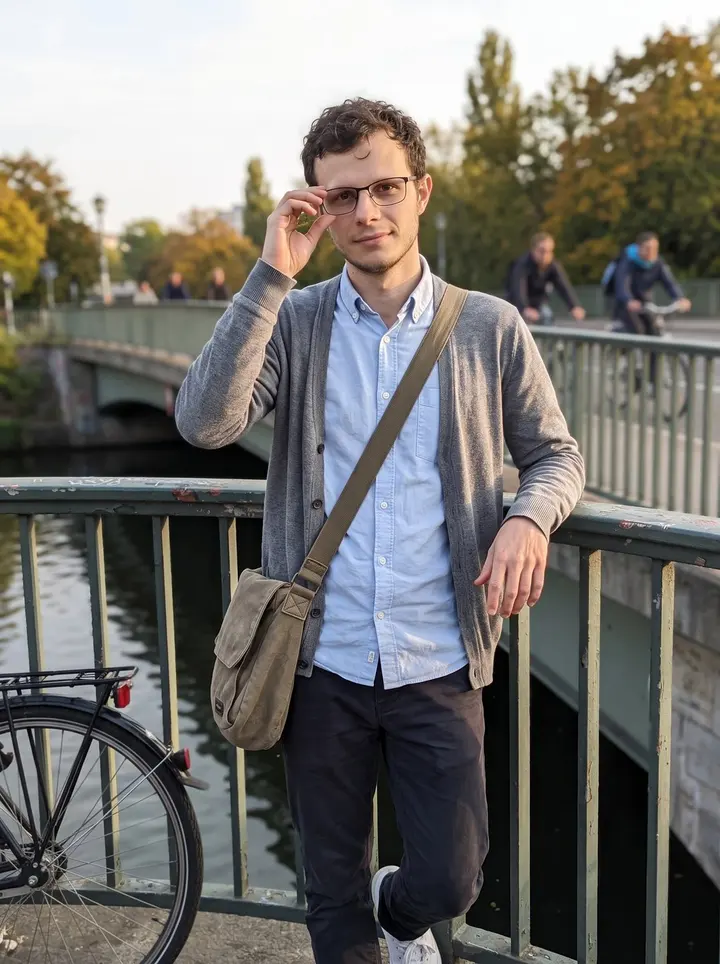 Łukasz, AI character: a quiet bridge over the Landwehrkanal in Kreuzberg, his city bike locked beside the railing
