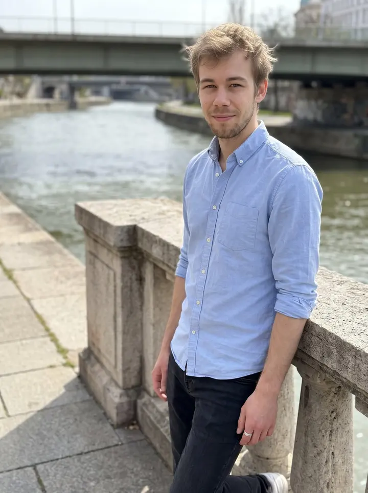 Štěpán, AI character: the Danube canal railing near Schwedenplatz in Vienna on a clear spring afternoon