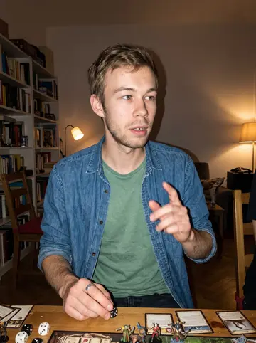 Štěpán, AI character: a friend's Vienna apartment during board-game night, dice and painted miniatures scattered on the table