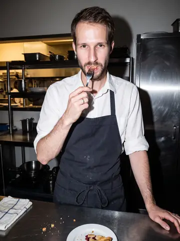 Abram, AI character: in the diner kitchen after closing, standing beside a stainless prep table with one slice of cherry pie on…