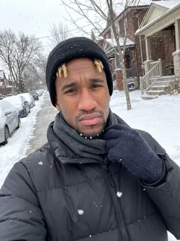 Alessio, AI character: snowy residential sidewalk near Trinity Bellwoods Park, parked cars covered in snow, bare trees